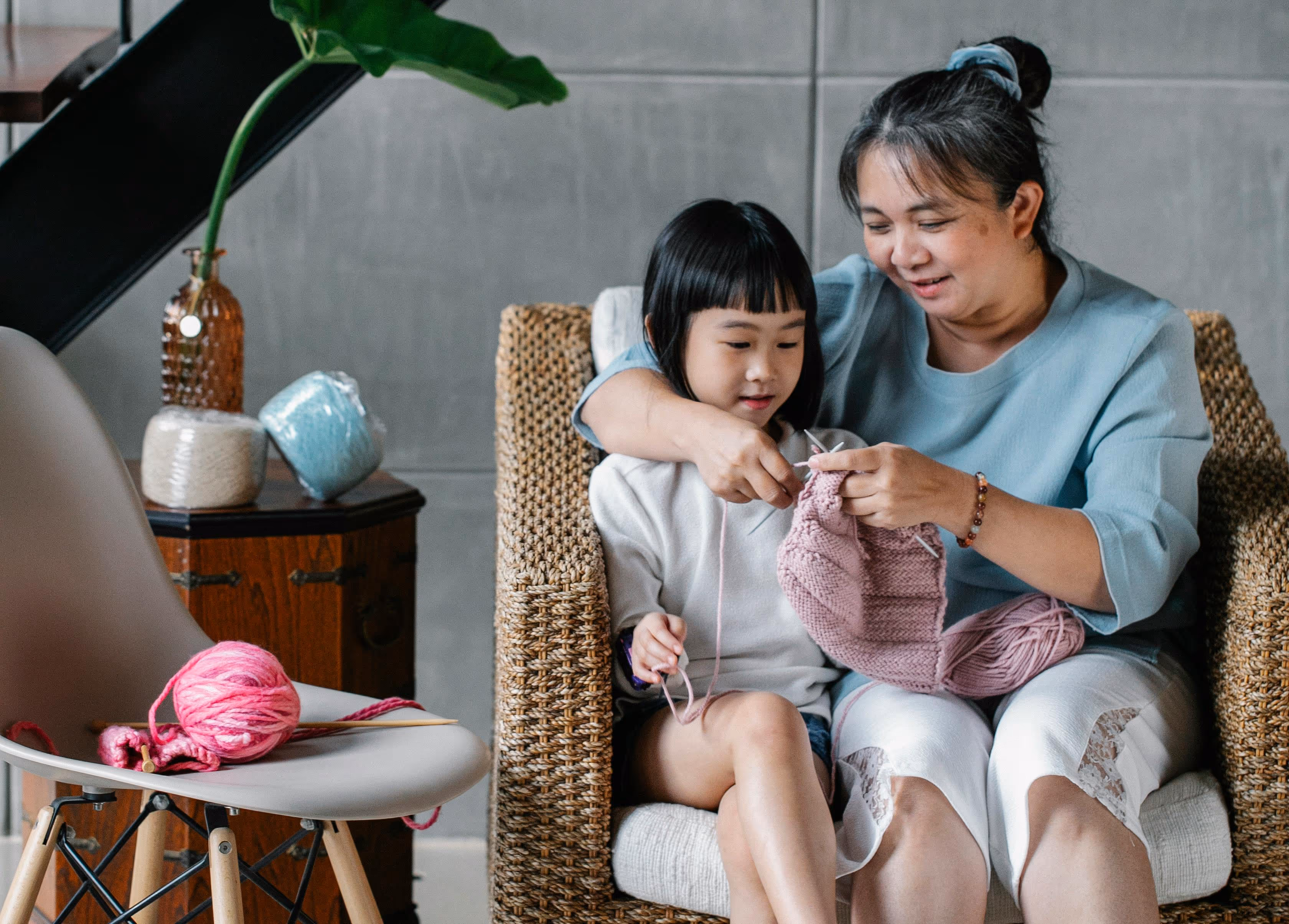 Grandmother teaching her grandchild to knit at home, symbolising family connection, care, and intergenerational support in Australia.