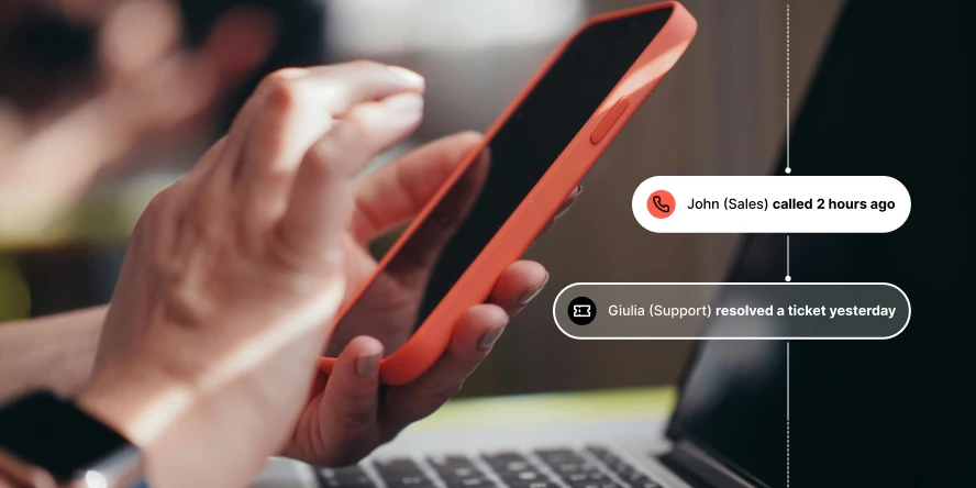 Person holding orange smartphone with notifications about John calling and Giulia resolving a ticket.
