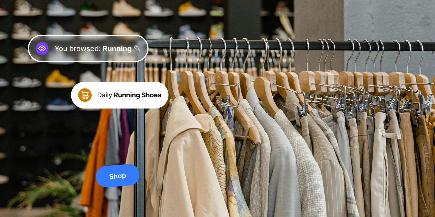 Clothing rack with various jackets and pants on wooden hangers in a store with shoes blurred in background.