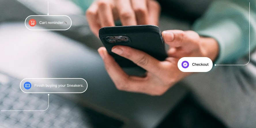 Person holding smartphone with icons for cart reminder, sneakers purchase, and checkout on-screen.