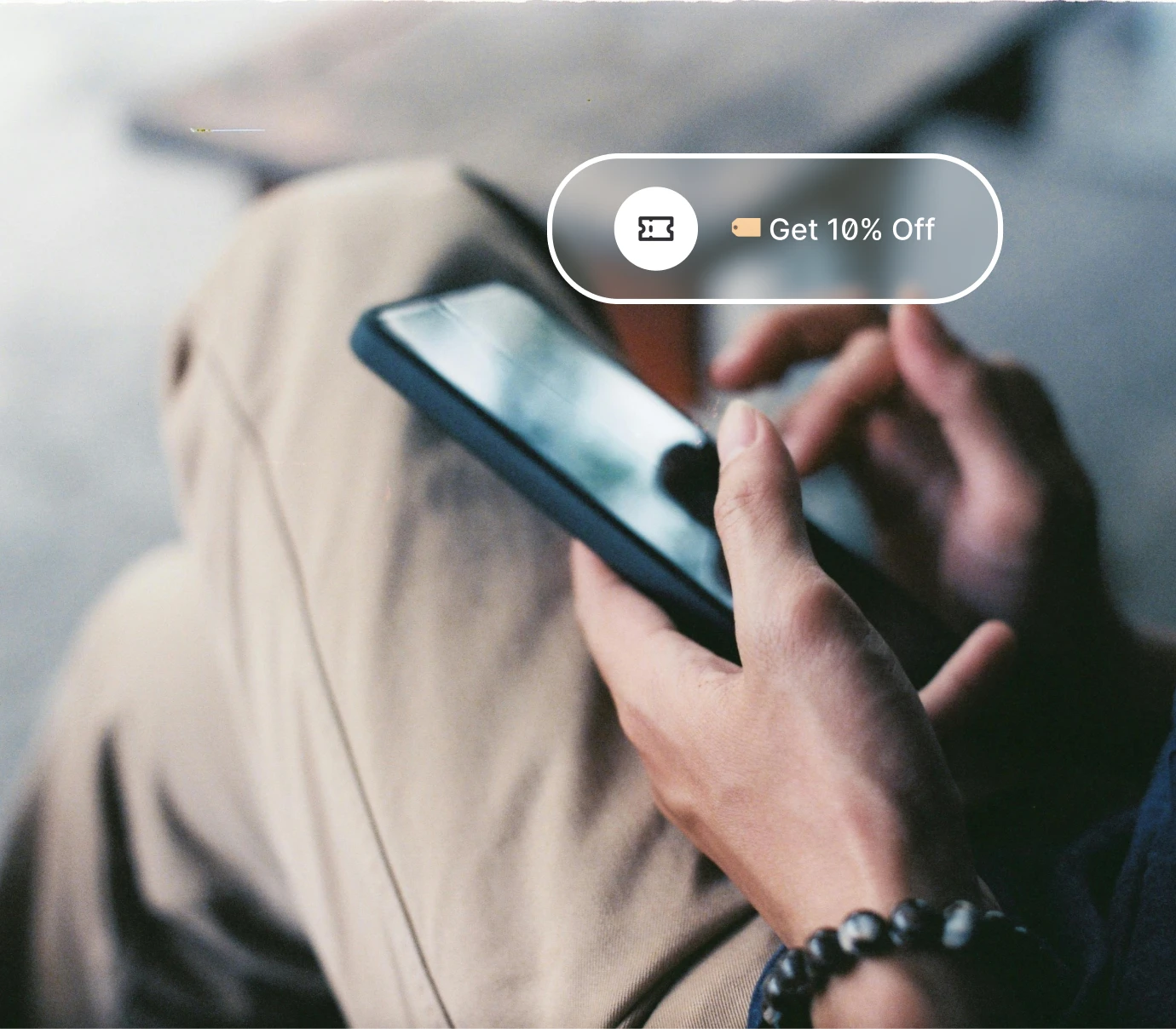 Person holding a smartphone with a 10% off discount badge overlay on screen.