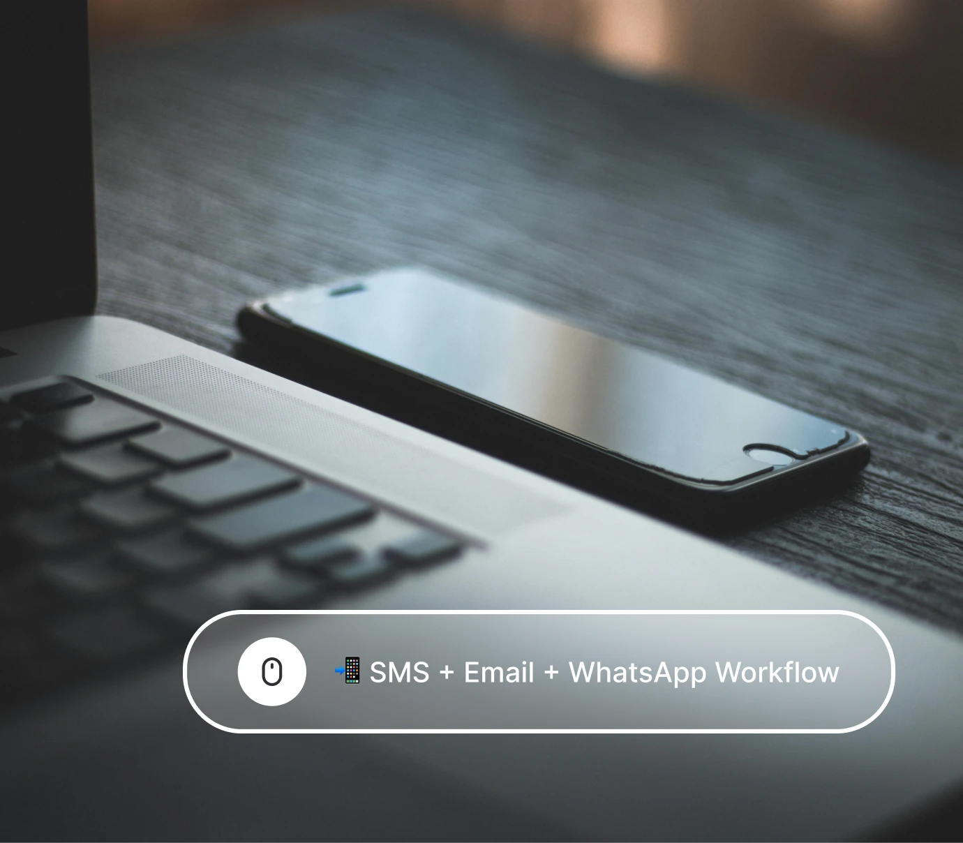 Close-up of a smartphone and laptop keyboard on a wooden desk with text overlay about SMS email WhatsApp.