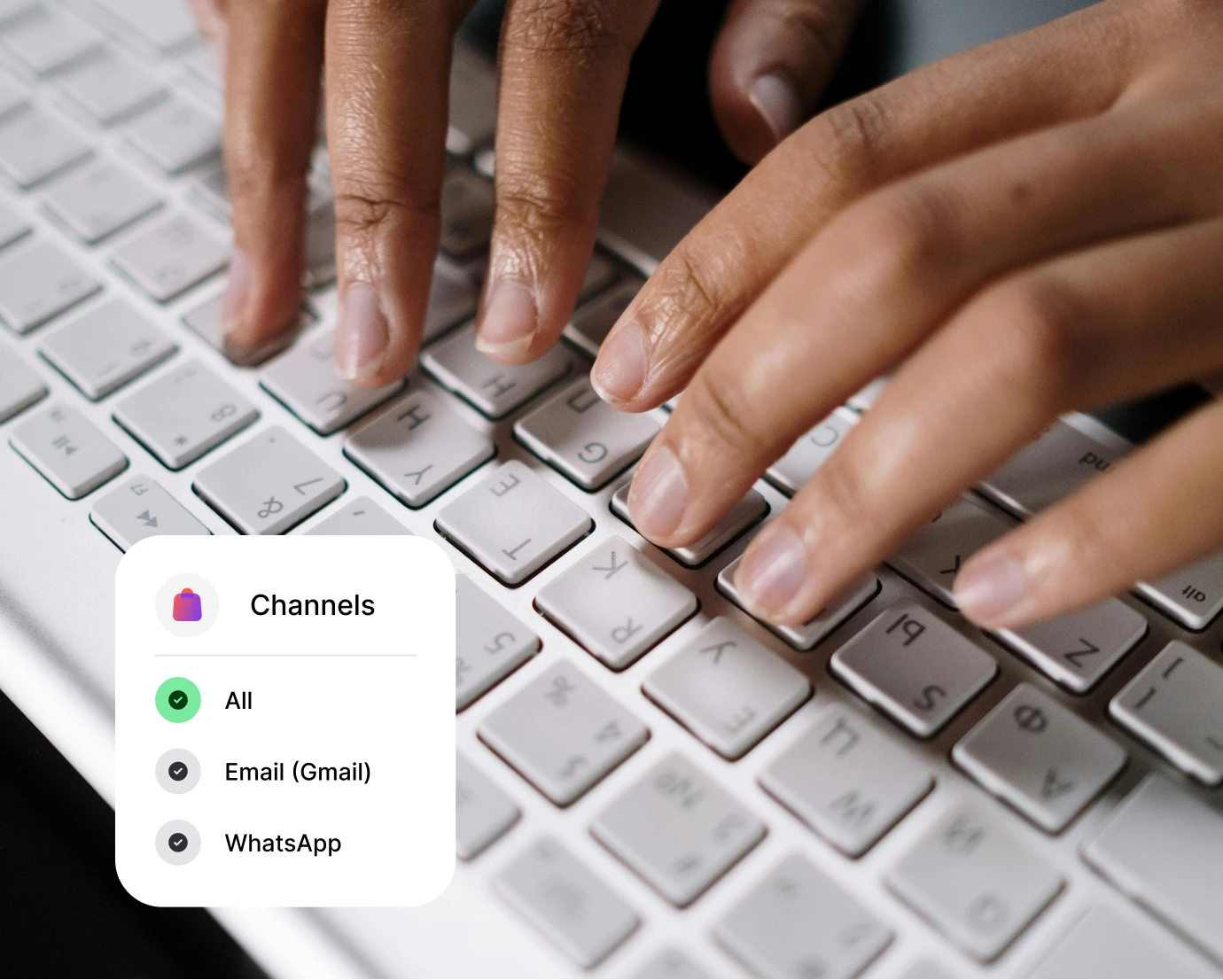 Hands typing on a white keyboard with a screen showing channel filters for All, Email, and WhatsApp.