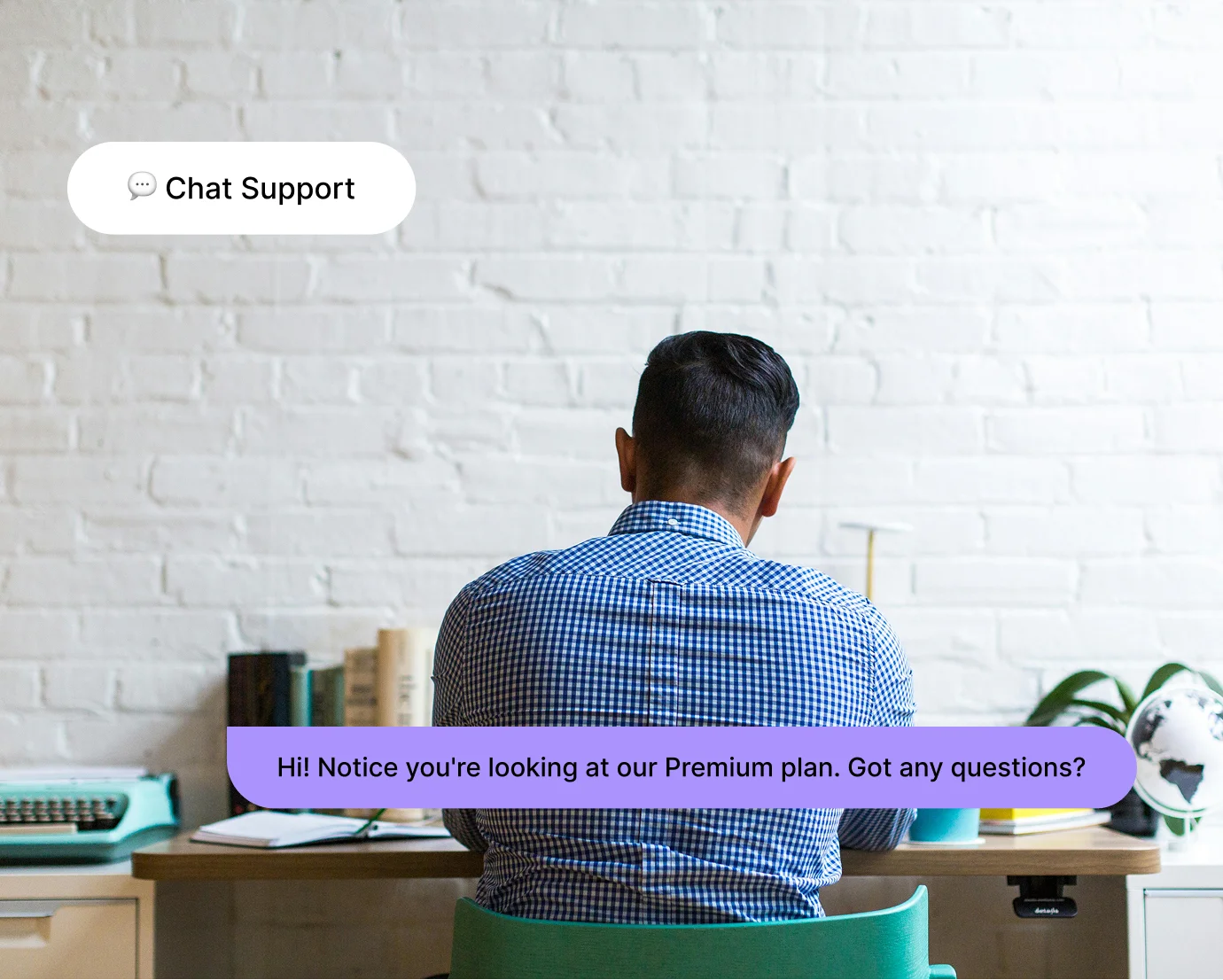 Man in blue checkered shirt sitting at desk with chat support message about Premium plan.