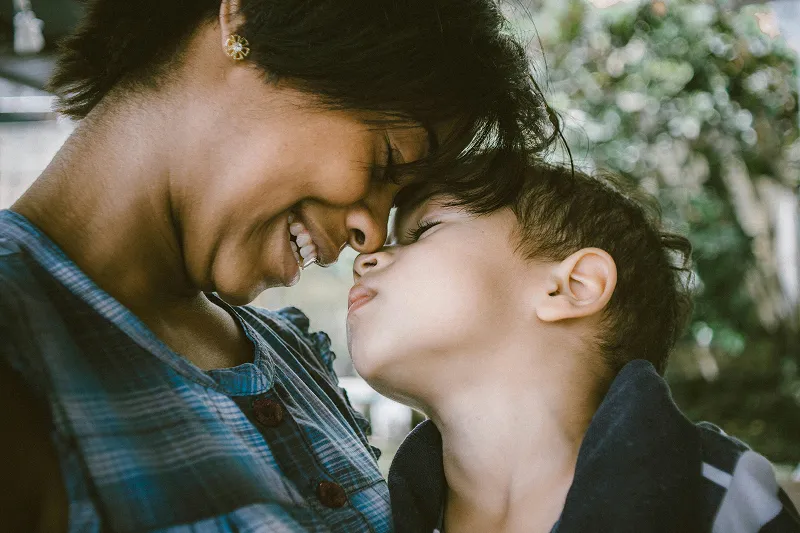 a mom and child close together smiling