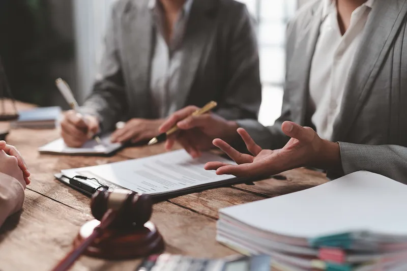 civil litigation image with people talking about legal cases at a table