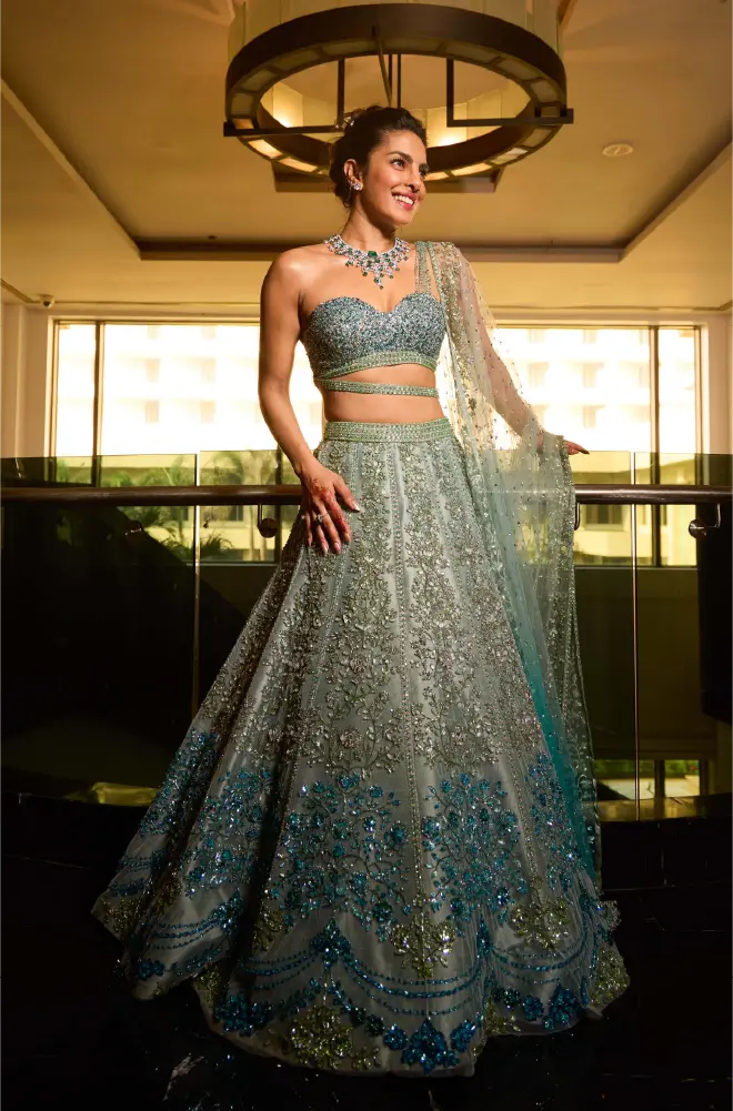 Priyanka Chopra Jonas in a custom seafoam green and turquoise Manish Malhotra lehenga; the intricate hand-embroidered ensemble features a bustier blouse and a sheer dupatta.