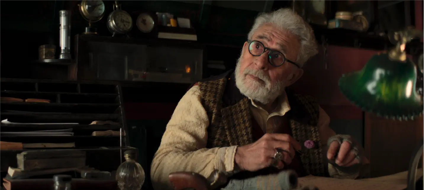 Production still from Gustaakh Ishq featuring Naseeruddin Shah as Ustaad, a master watchmaker, looking up thoughtfully in his vintage workshop surrounded by clocks and horology tools.