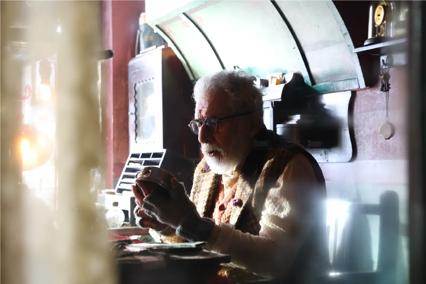 Naseeruddin Shah as Ustaad, a watchmaker, meticulously examining a vintage timepiece in his workshop in a production still from Gustaakh Ishq.