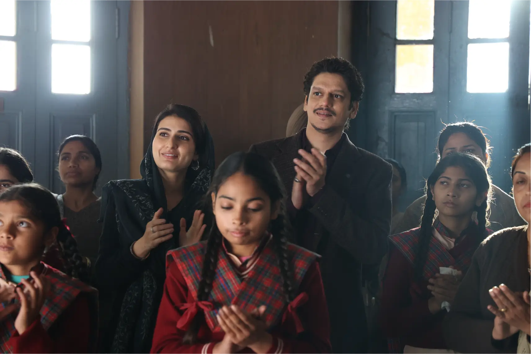 Fatima Sana Shaikh as Minni and Vijay Varma as Pappan standing among a group of school children in a production still from the film Gustaakh Ishq.