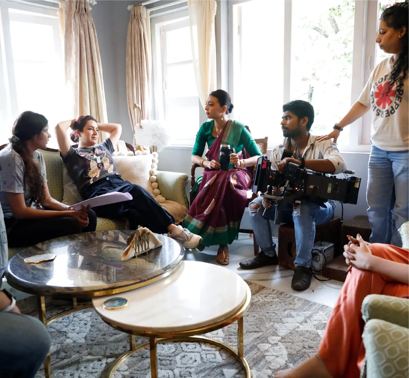 A BTS still from saali mohabbat featuring Radhika Apte and Tisca Chopra having a conversation while the film crew looks on.