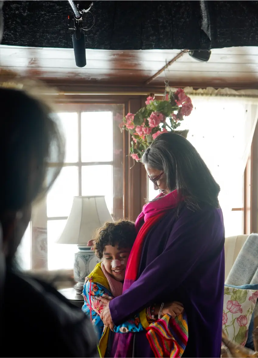 Emotional moment between Shabana Azmi and young actor Rohaan Singh on the set of Bun Tikki filming an indoor scene in a cozy living room setting.