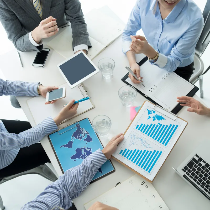 Professionals discussing reports and graphs at a business meeting.