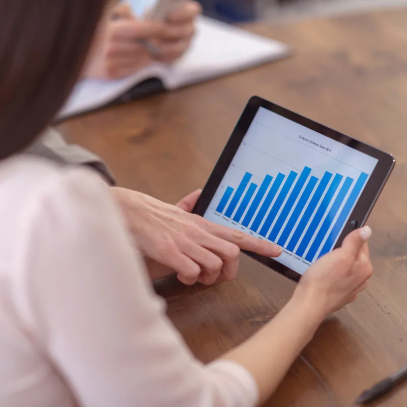 A woman pointing at a tablet.