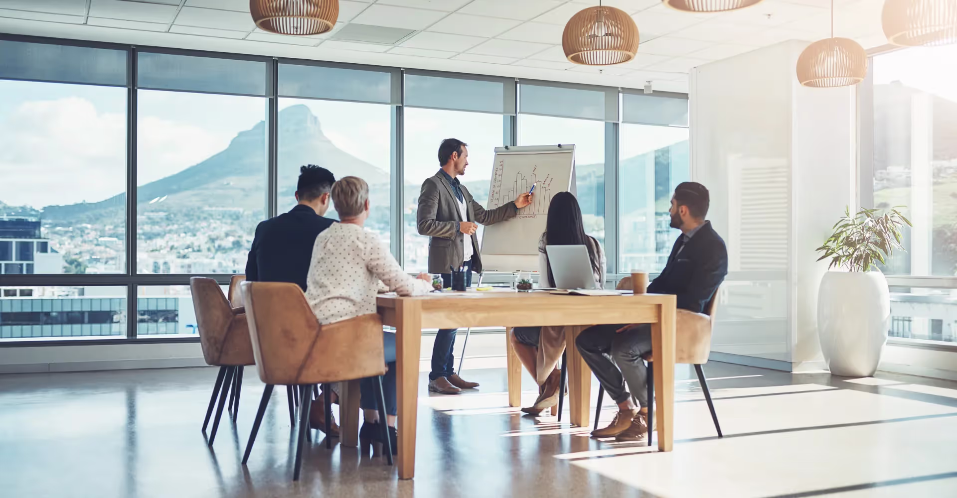 Business presentation in a modern office with a mountain view in the background.