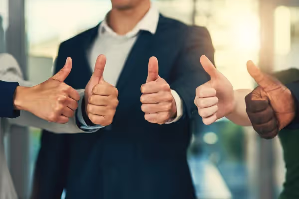 Four people giving a thumbs-up gesture in agreement or approval.