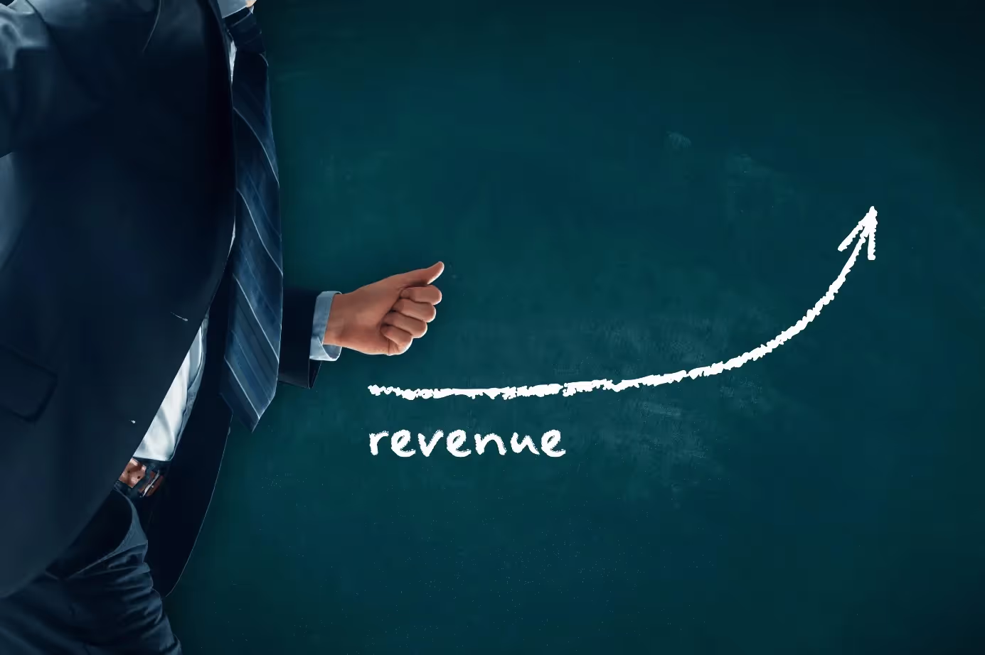A man pointing at a graph with the word revenue trending upward.