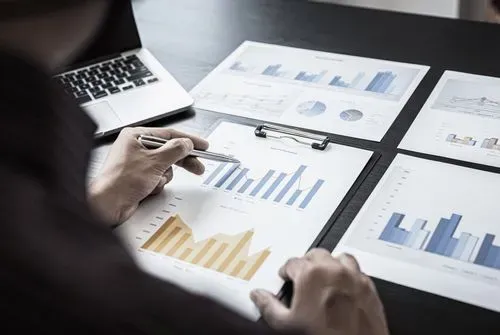 A man is looking at graphs on a desk.