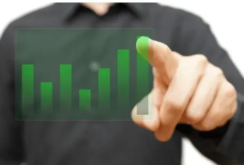 A man is pointing at a graph on a screen.