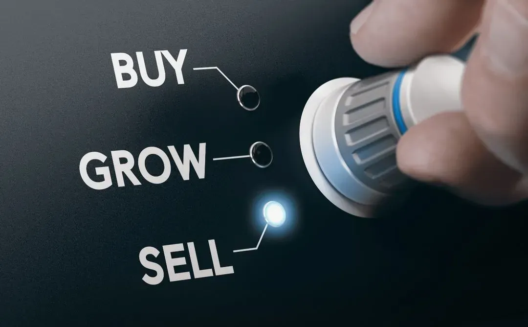 A person pushing a button that says buy, grow, sell.