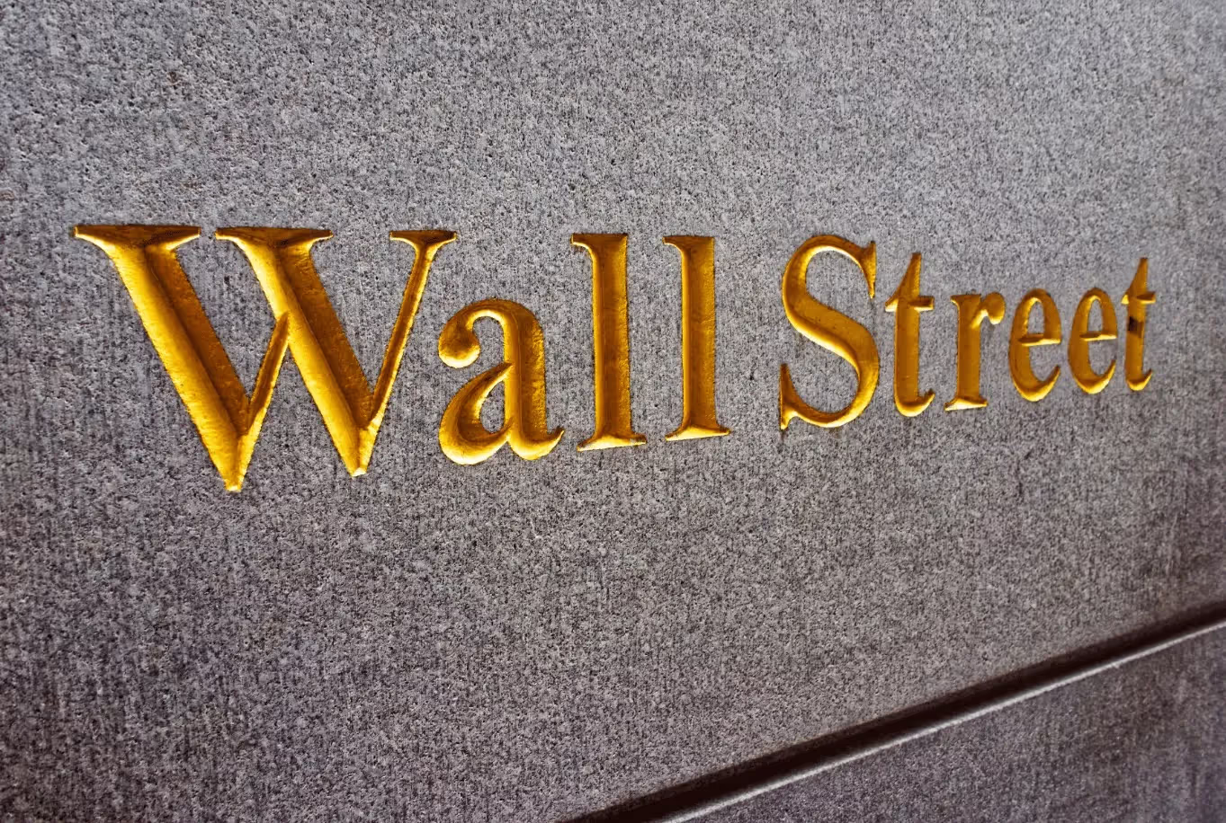 A Wall Street sign is shown on a building.