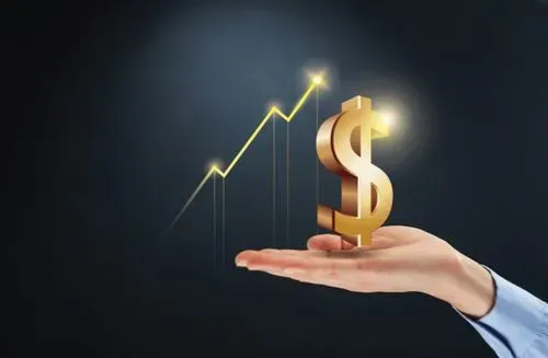 A businessman's hand holding a dollar sign on a black background.