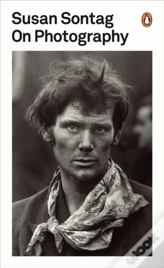 Cover of Susan Sontag's book On Photography featuring a black and white portrait of a man with disheveled hair and a patterned scarf.