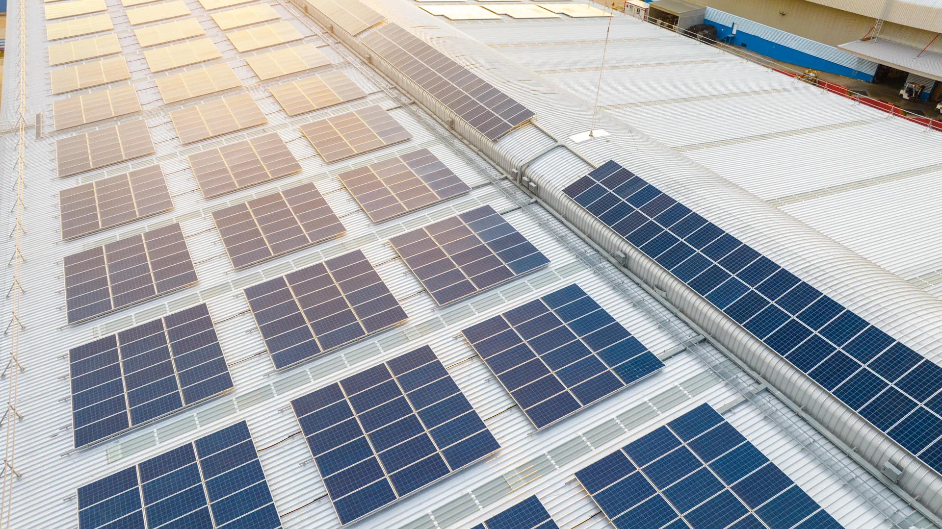 Aisle between large gray server racks with overhead fluorescent lights in a data center.
