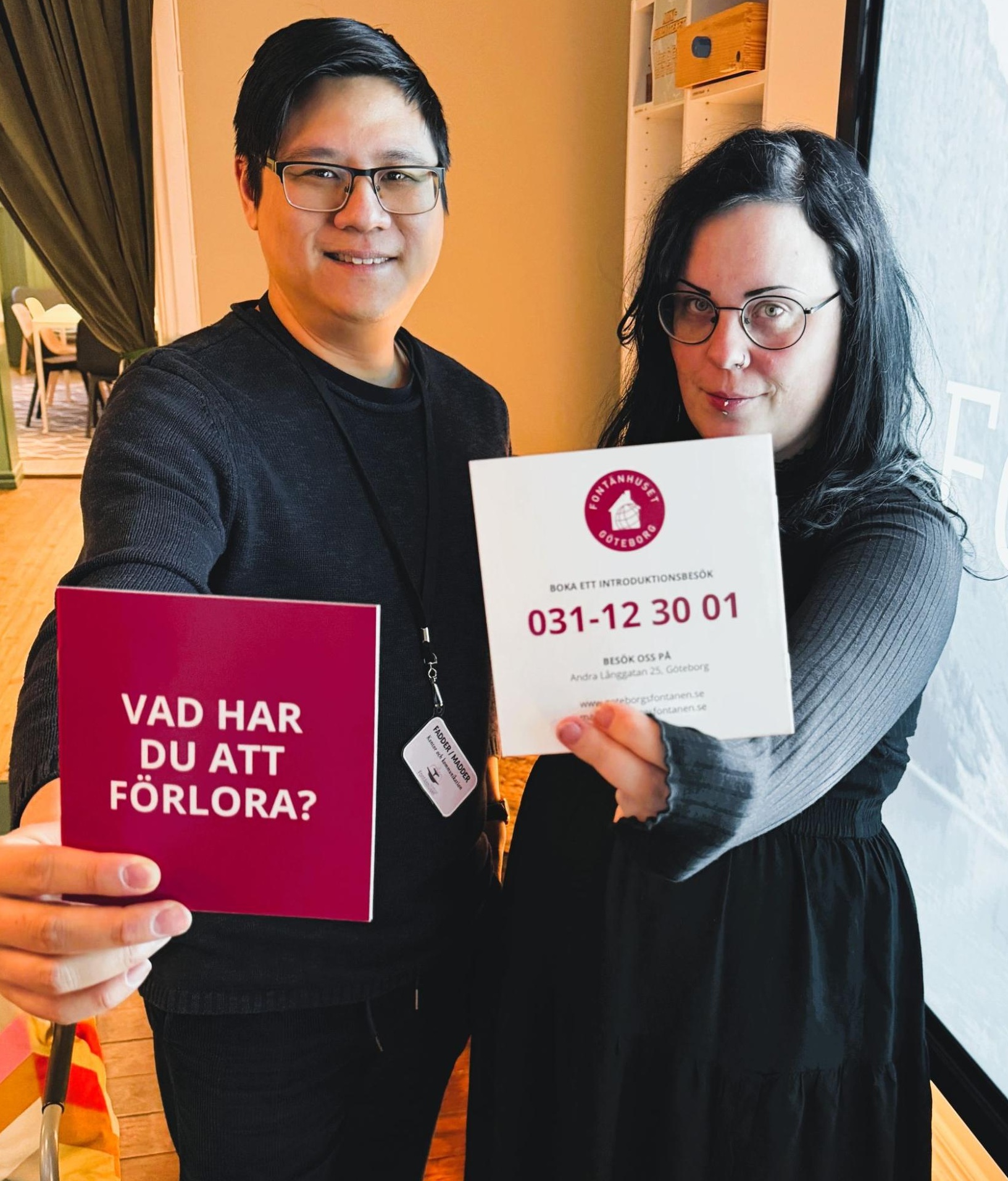 Två personer håller fram kort, ett rött med texten 'Vad har du att förlora?' och ett vitt med kontaktinformation för Fontanhuset Göteborg.