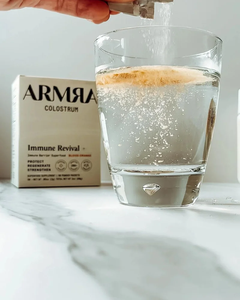 mixing ARMRA Blood Orange into a glass of water