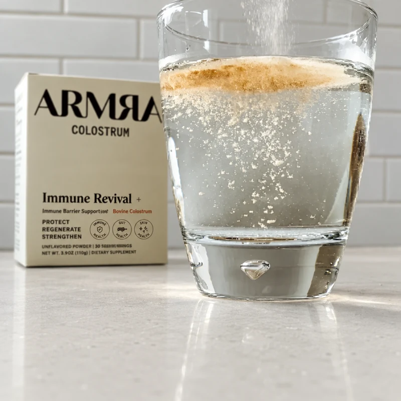 ARMRA colostrum and prepared glass on a light quartz kitchen counter