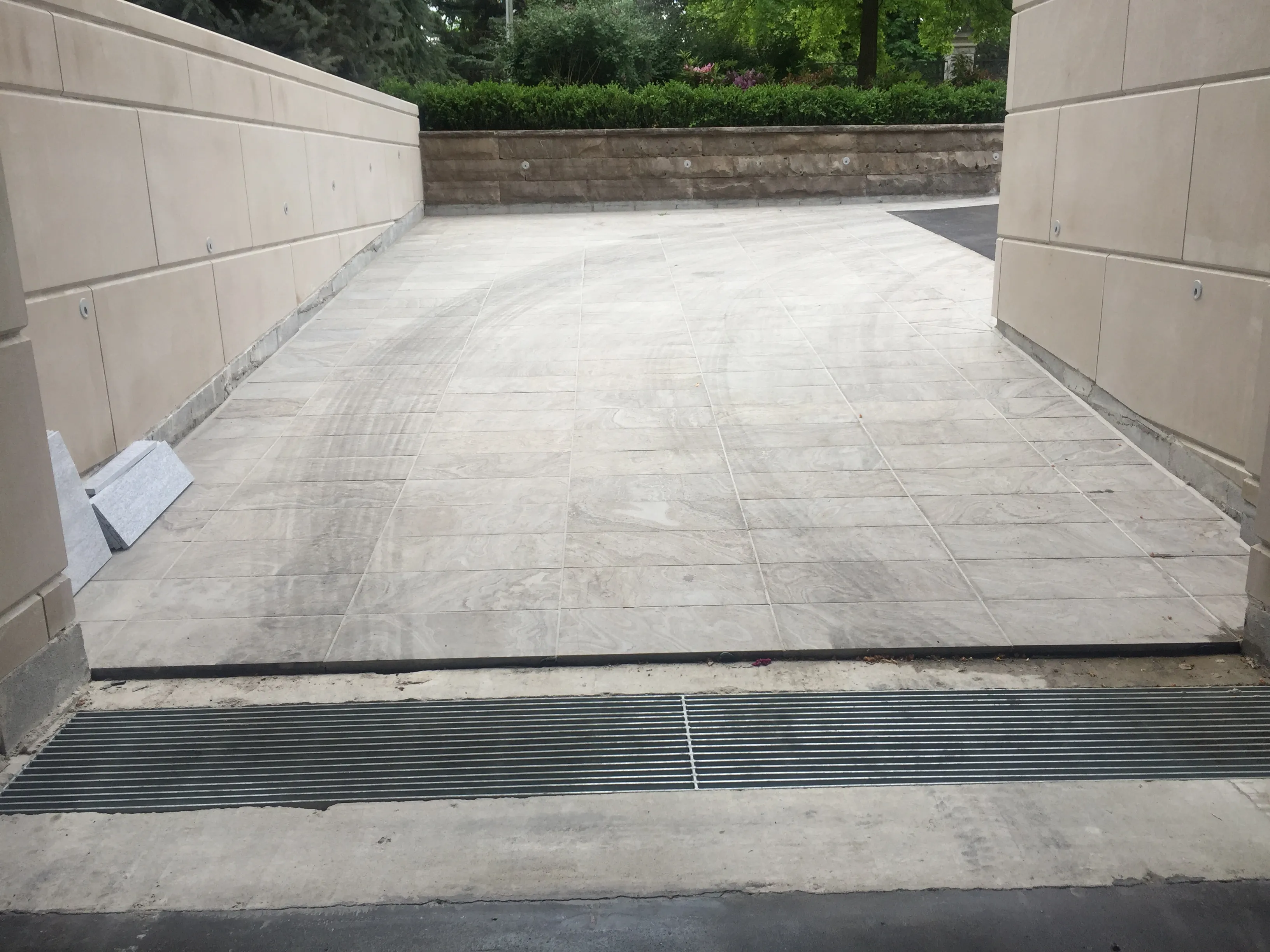 Trench drain installed across a finished concrete driveway