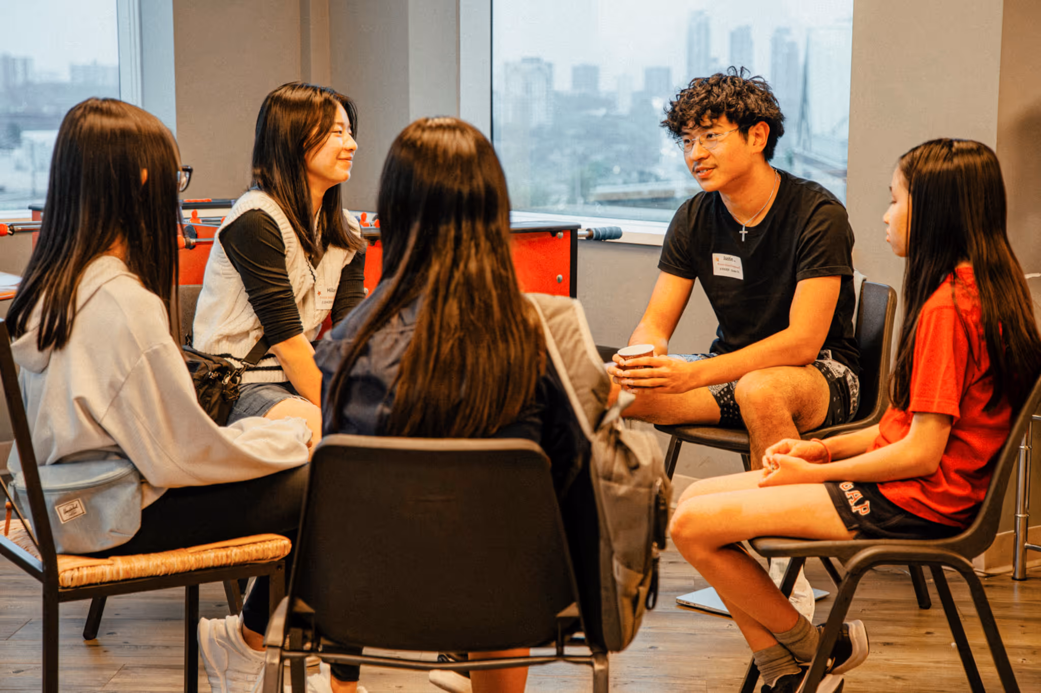 AFC high school students sitting in a small group circle engaged in a bible study or discussion