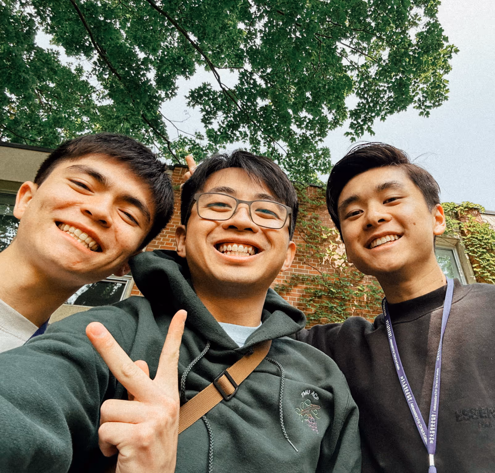 AFC college students hanging out together on campus, one making a peace sign