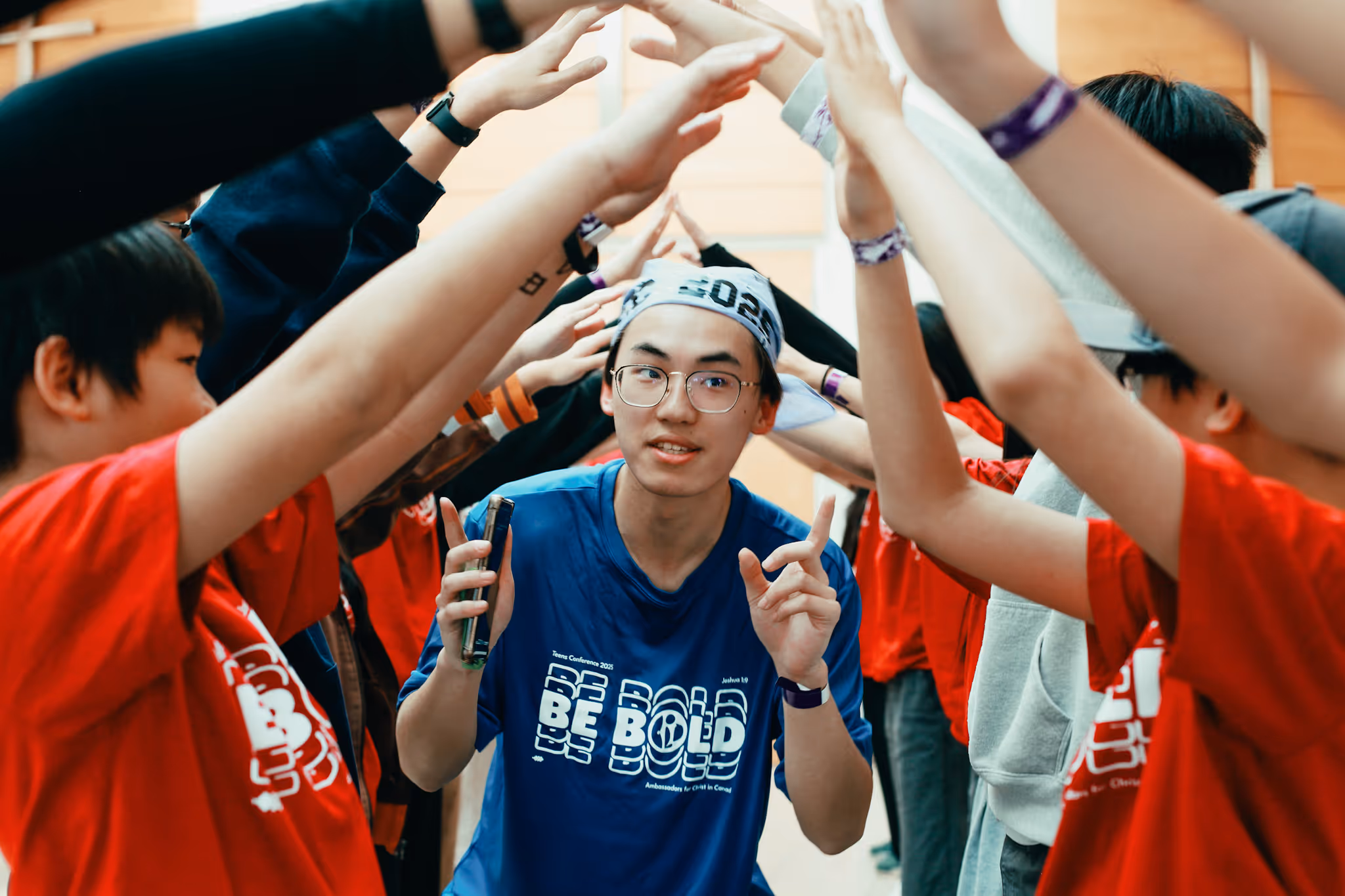 AFC student walking through a tunnel of raised arms during an encouragement activity at a conference