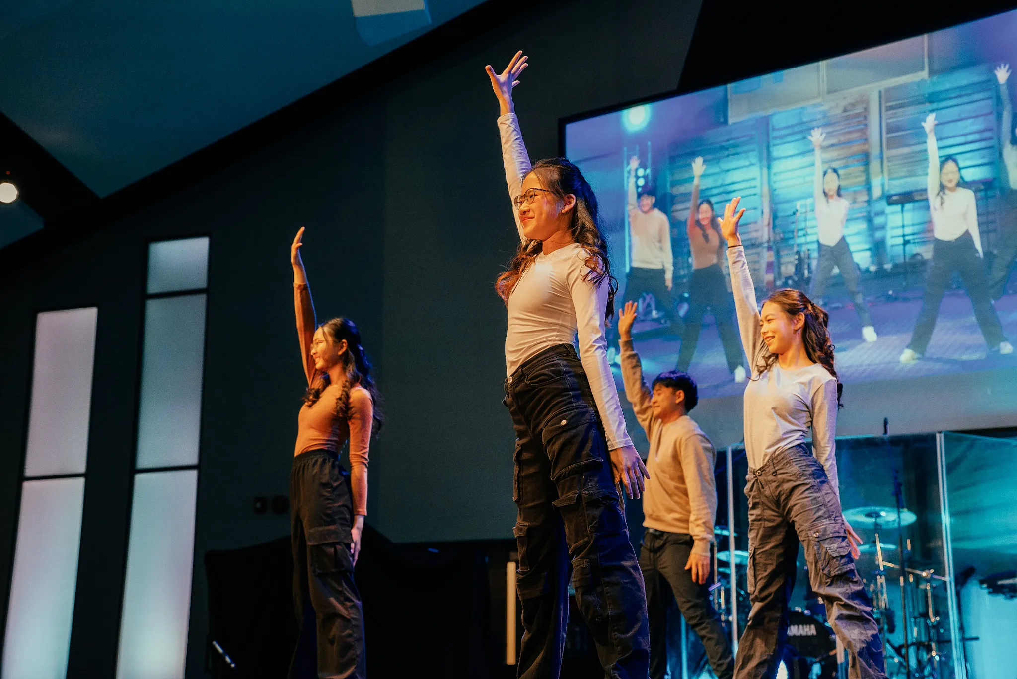AFC teens performing a synchronized worship dance on stage at a conference