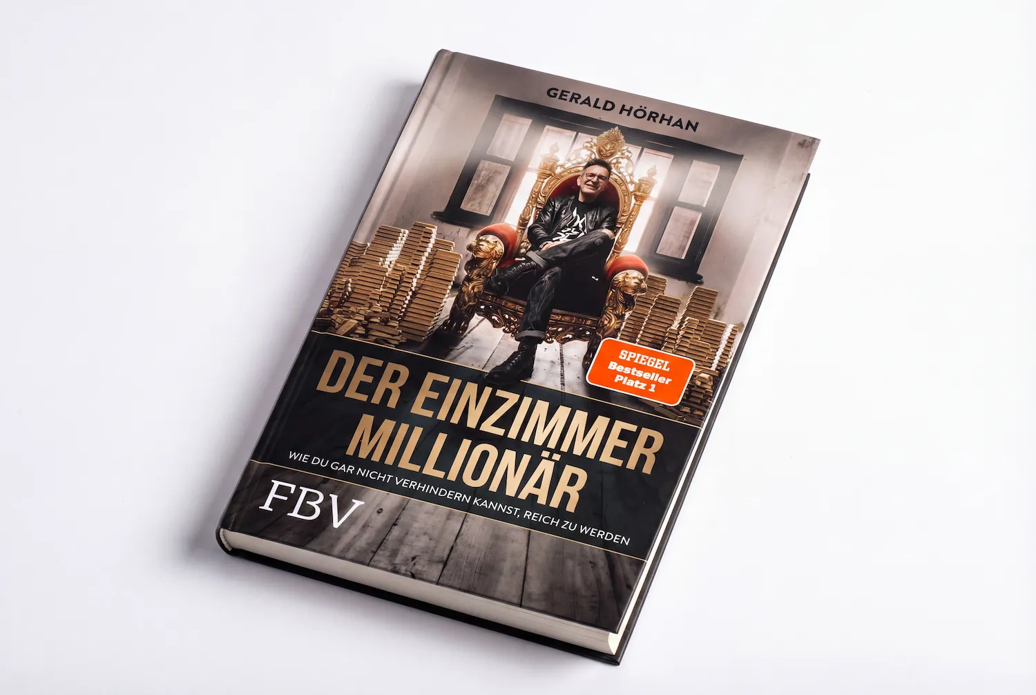 Buchcover von 'Der Einzimmer Millionär' von Gerald Hörhan mit einer Person auf einem goldenen Thron und Geldstapeln im Hintergrund.