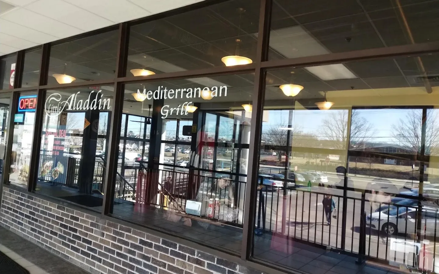 A window of a restaurant with the name Mediterranean Grill on it.