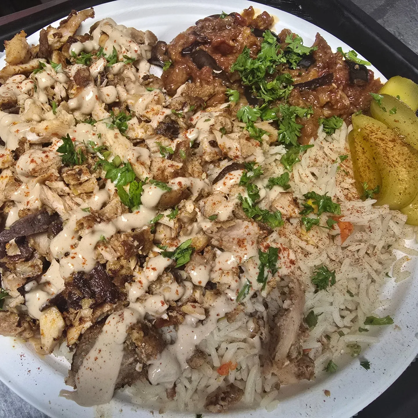 A plate of food with rice, meat, and vegetables.