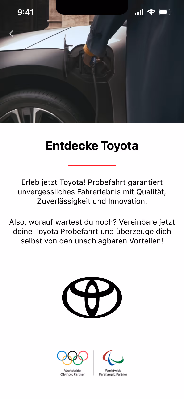 Person charging a white electric car, with text promoting Toyota test drives and the Toyota logo below, plus Olympic and Paralympic partnership logos.