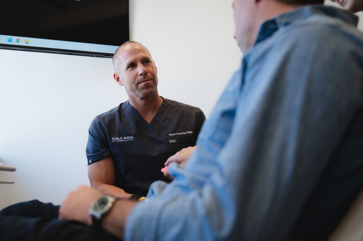 Friendly dentist examining anxious patient in modern Boulder dental office at Table Mesa Dental