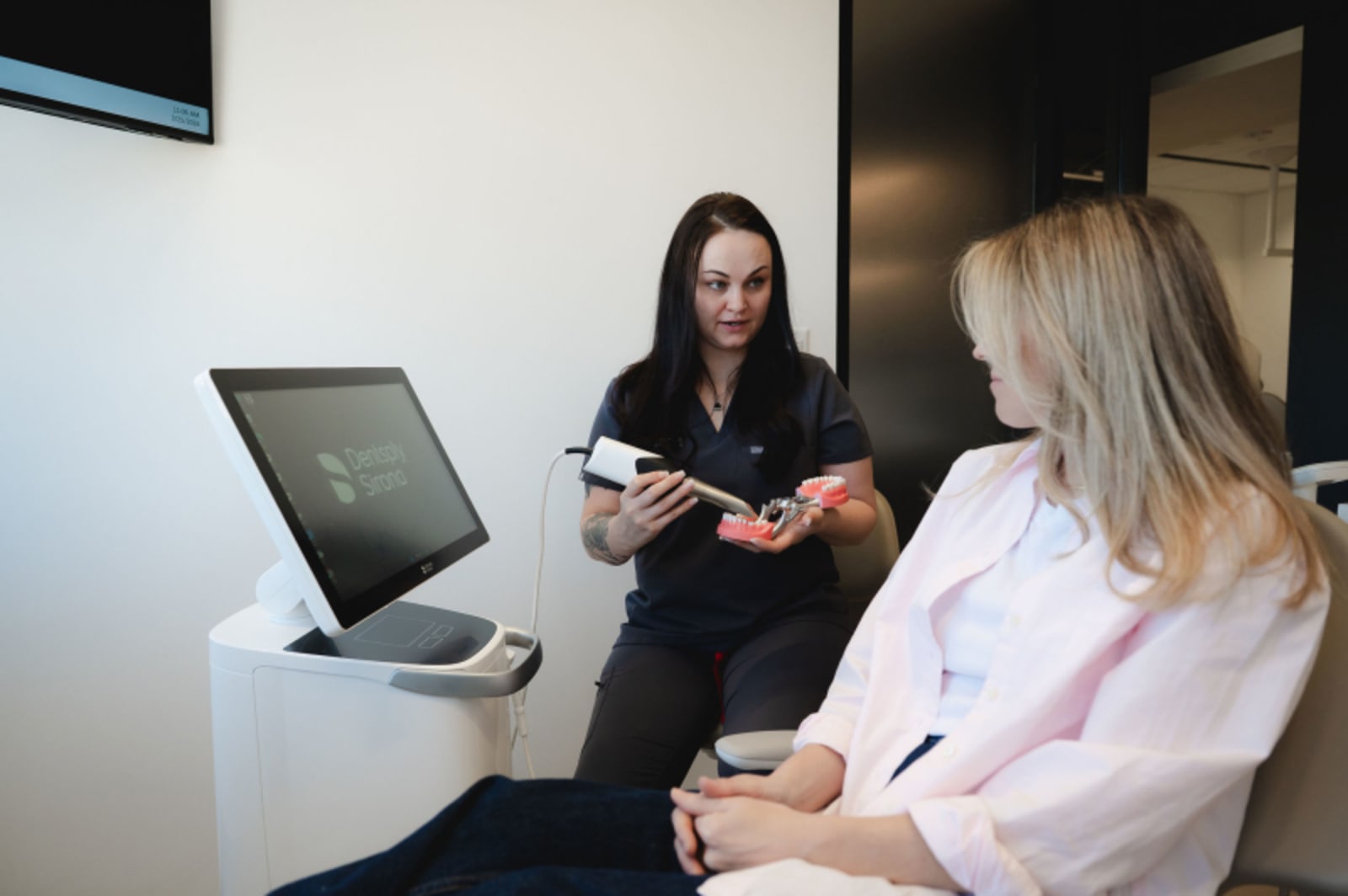Female staff member and patient reviewing dental information on tablet