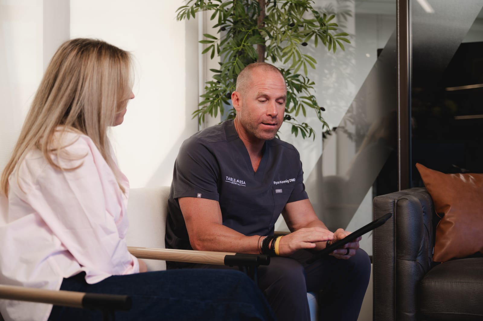 Dental team member having friendly conversation with patient at front desk