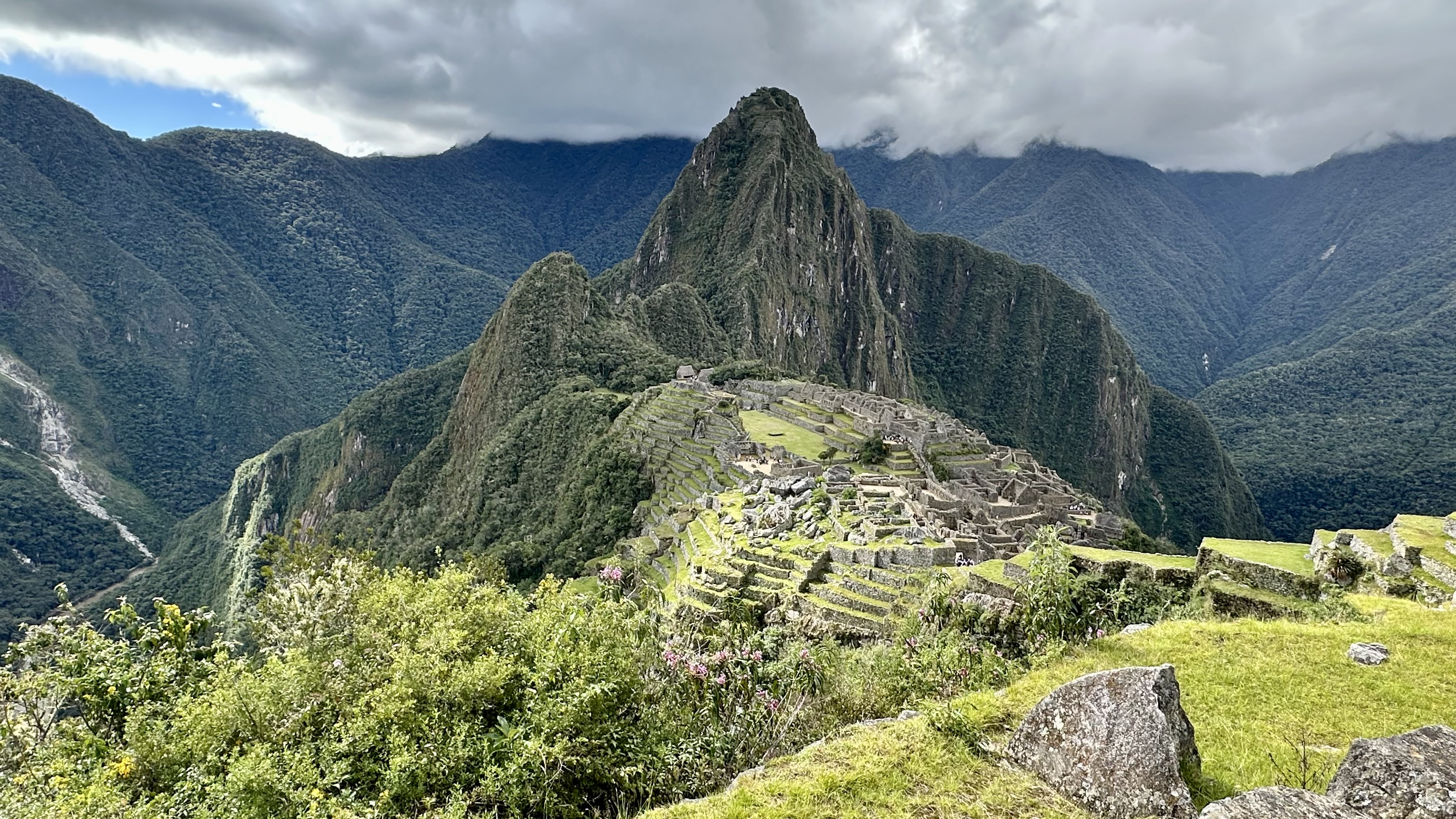 Hiker standing on summit with snow-capped mountain backdrop