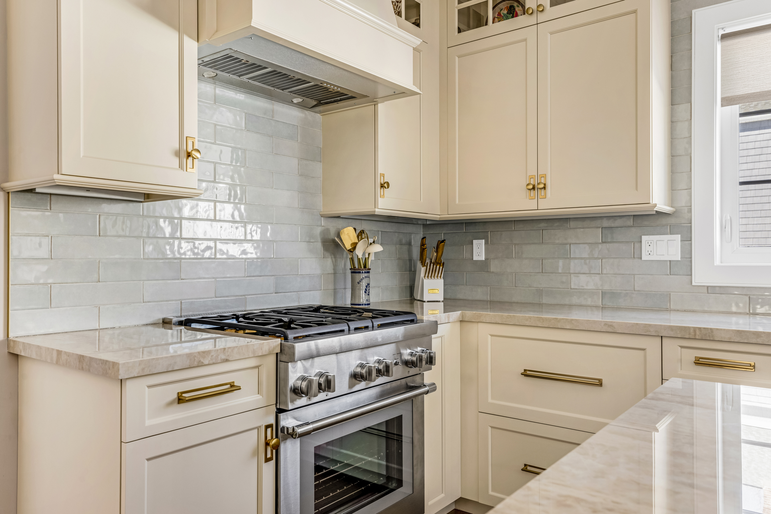 Transitional kitchen with stainless steel double oven range and white cabinetry on hardwood floor.