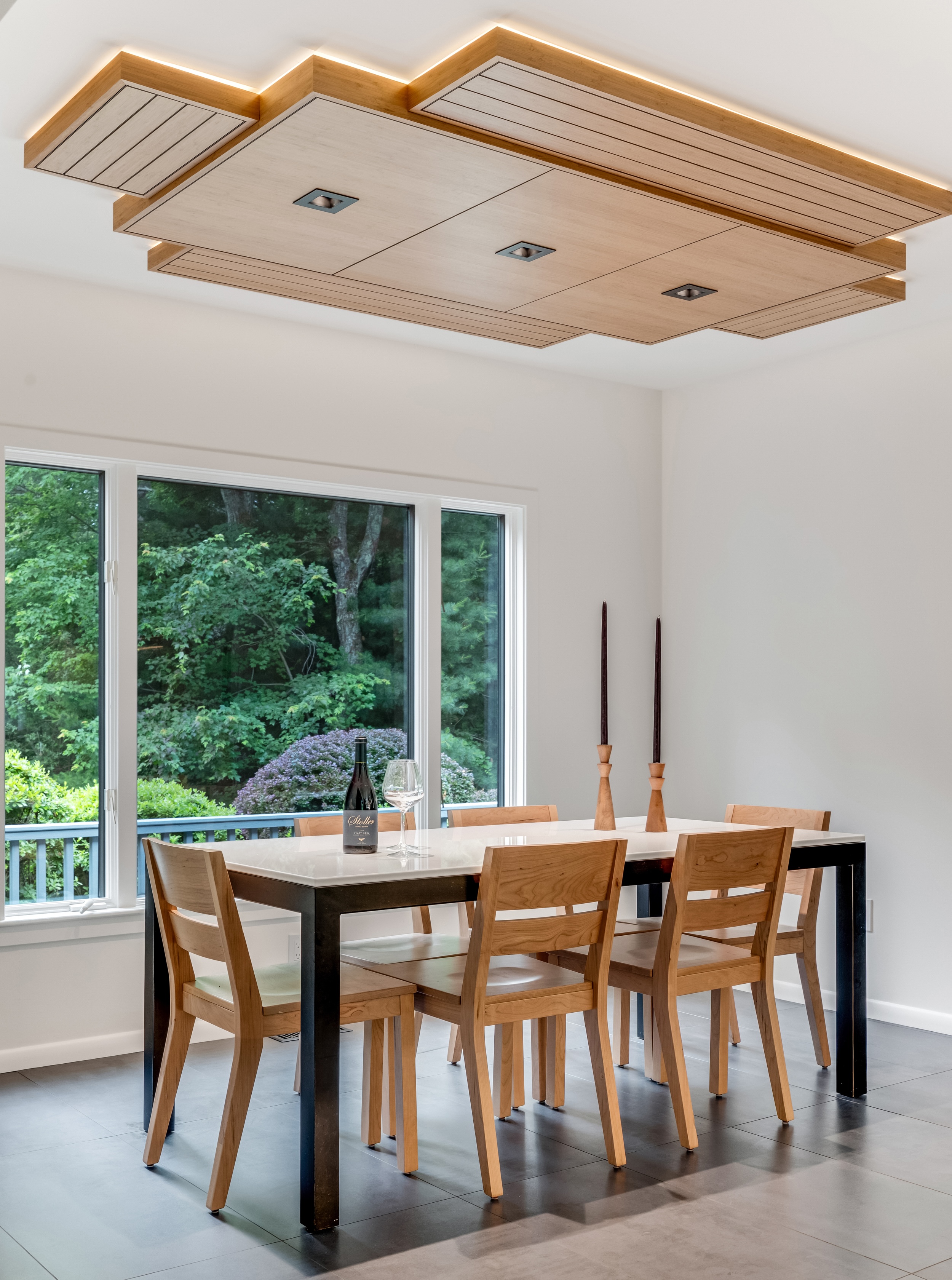 Custom bamboo ceiling with recessed lighting over the dining area of a Marshfield first floor remodel, with a white quartz table and black steel base