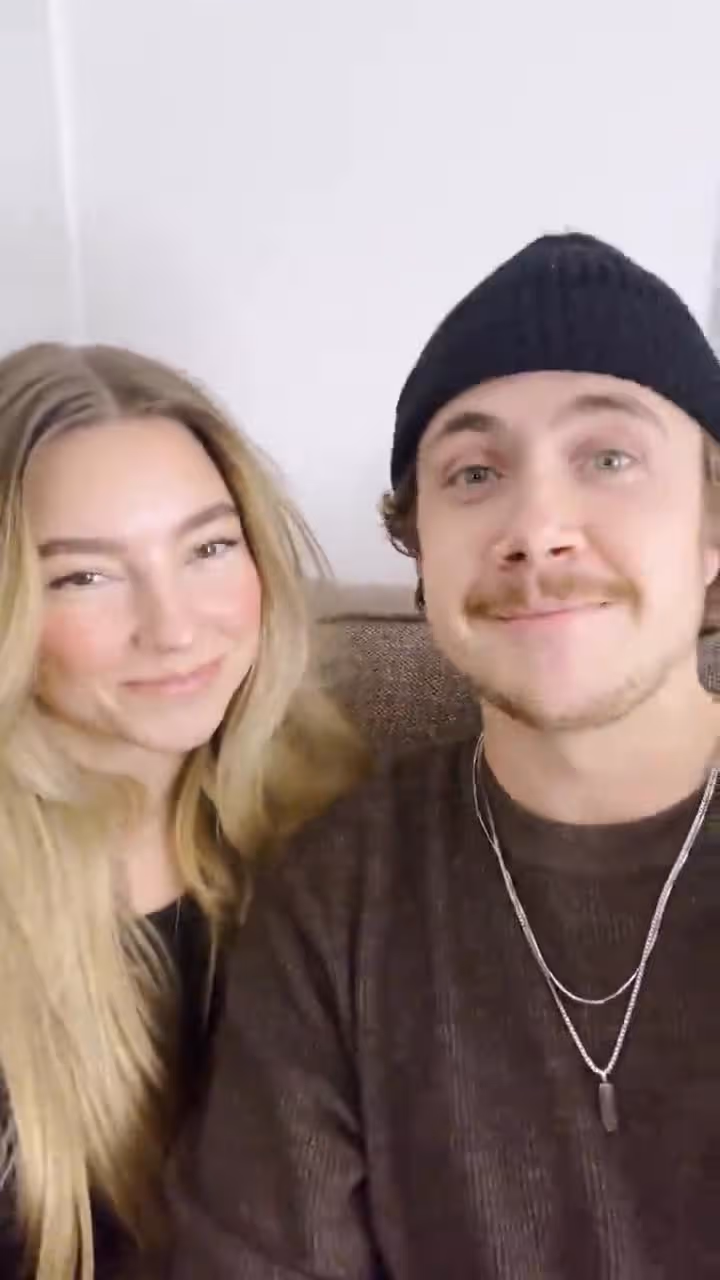 Young couple smiling at church or hospital event, wearing casual attire and friendly expressions together.