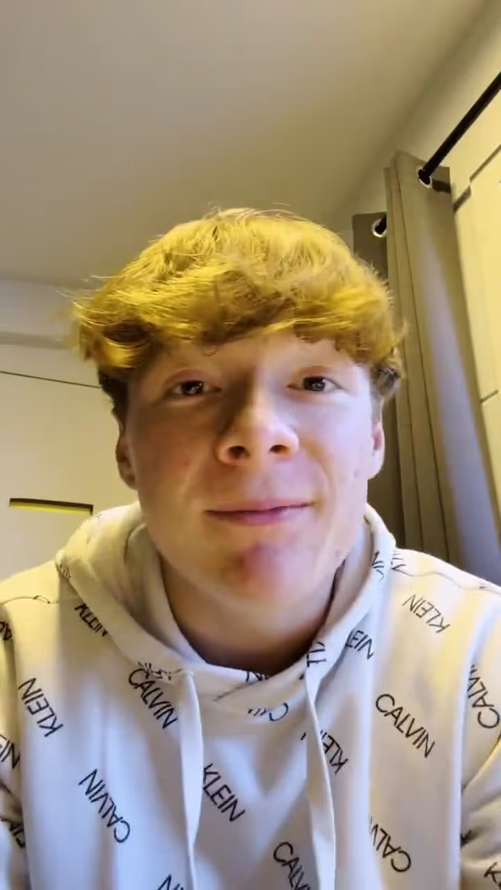 Young man with blond hair wearing Calvin Klein hoodie in hospital or church setting.