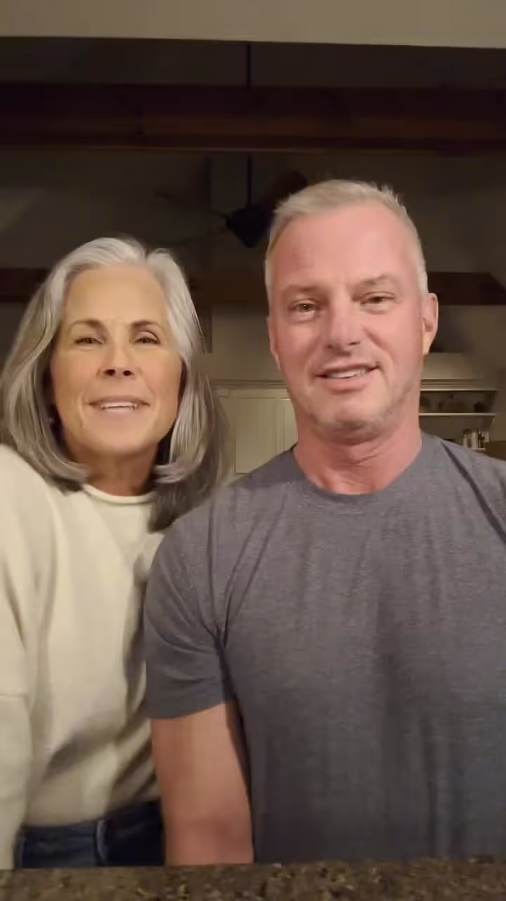 Couple smiling together indoors, likely church or hospital supporters or volunteers standing side by side.