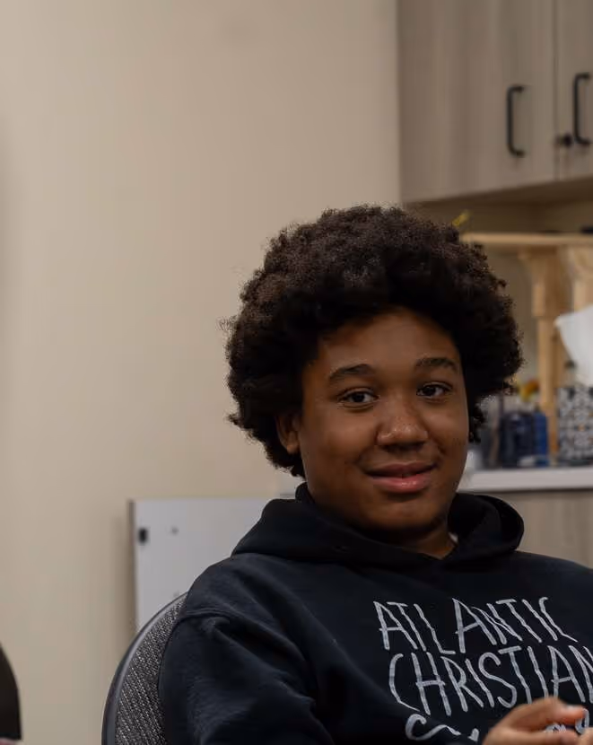 Young girl wearing Atlantic Christian church hospital branded hoodie smiling.